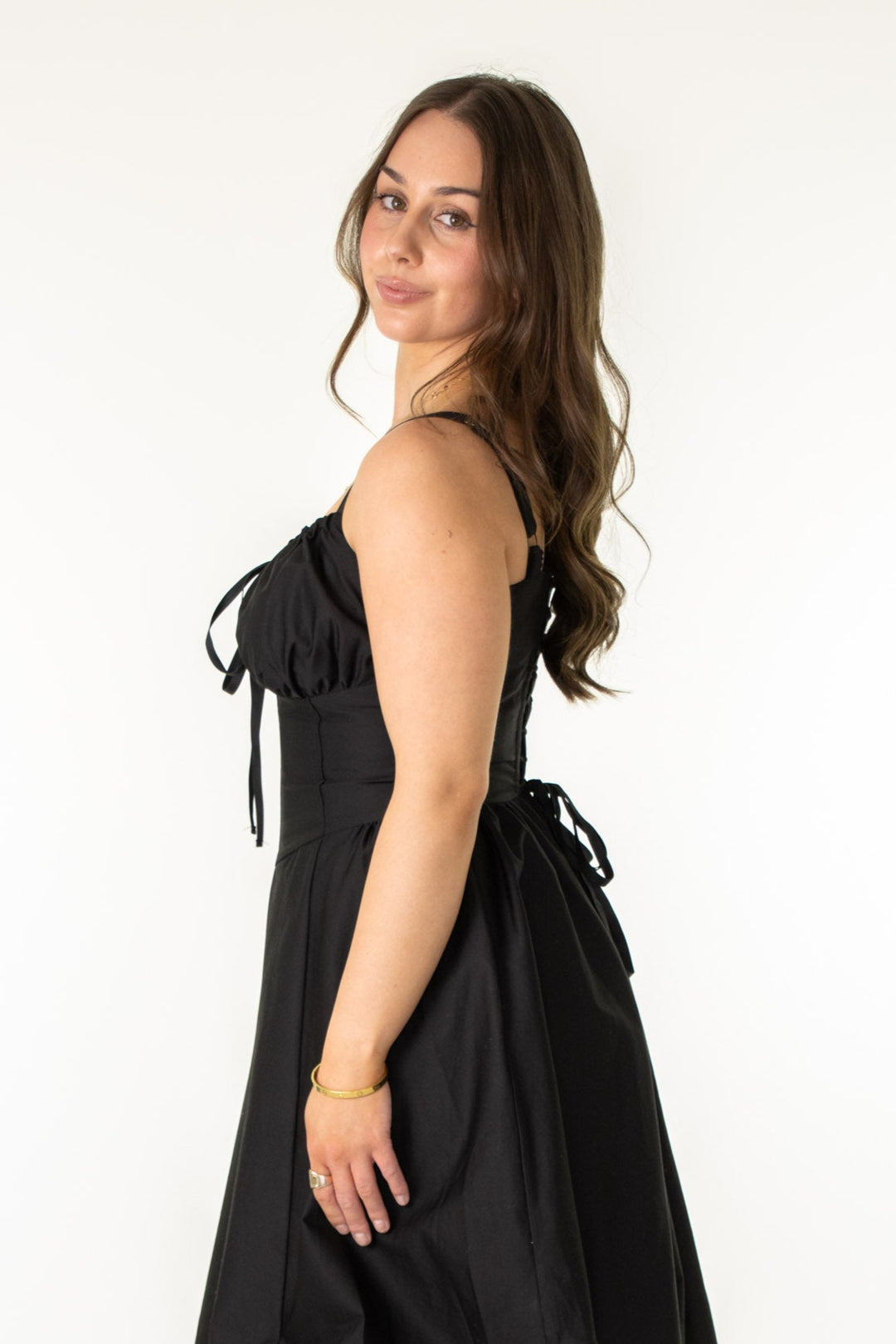 Woman wearing a black dress with bow details on a white background
