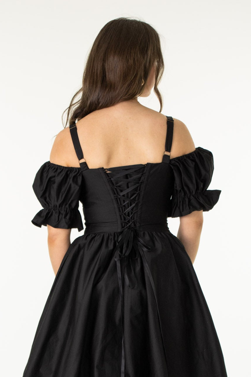 Woman wearing a black off-shoulder dress on a white background